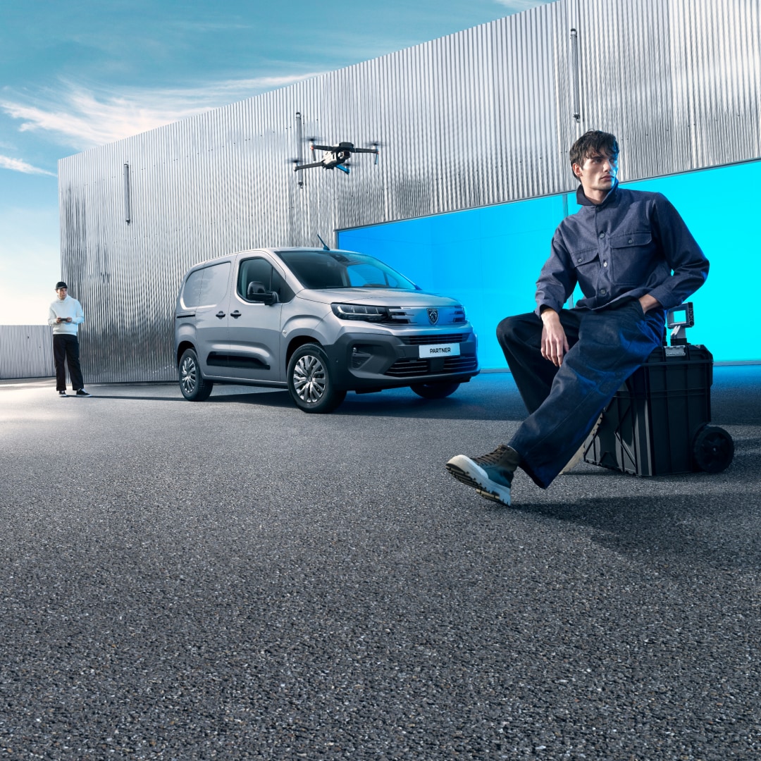 Een man staat bij een PEUGEOT E-Partner