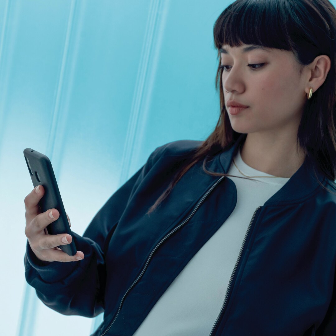 Een vrouw gebruikt de MyPeugeot-app op haar smartphone