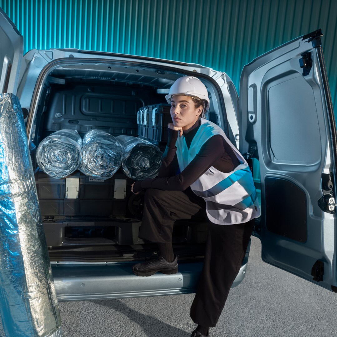 Een vrouw laadt goederen in een PEUGEOT E-Partner